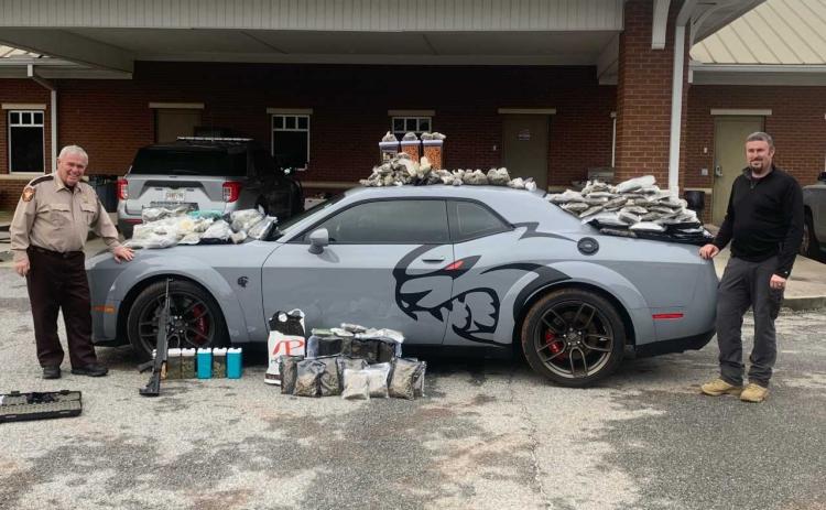 Hart County Sheriff Mike Cleveland (left) and Capt. Chris Carroll stand with the seized “Jail Break Hell Cat” Dodge Challenger, drugs and weapons.