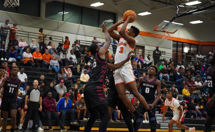 Senior forward Tahj Johnson puts up an acrobatic shot over the defender in the 55-50 home loss to Hebron Christian. Photo taken by Lexie Wheless.