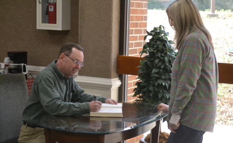 New York Times bestselling author John Cribb (left) signs a copy of his latest book, “The Rail Splitter” for Gwen Walters (right), of Hartwell, during a book signing and talk at the Hart County Library Jan. 26. 