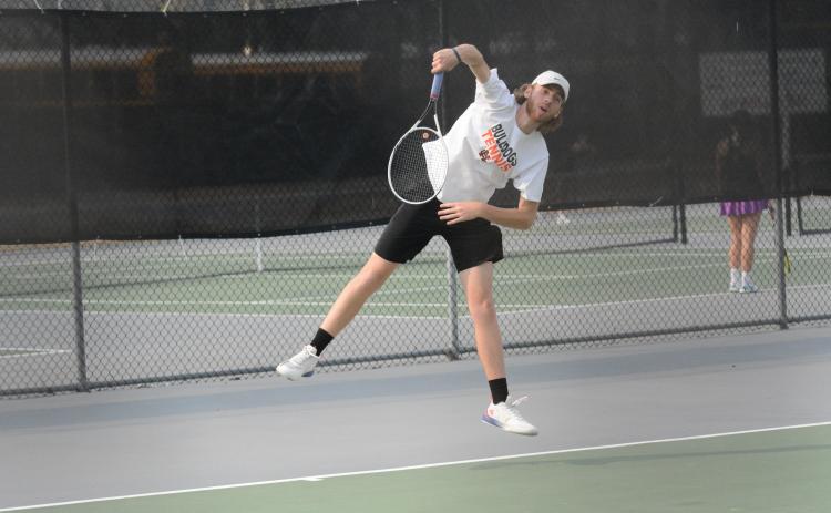 Senior Daniel Leard serves to a Franklin County Lion in Monday’s home match as the boys fell 5-0 and the girls won 3-2.