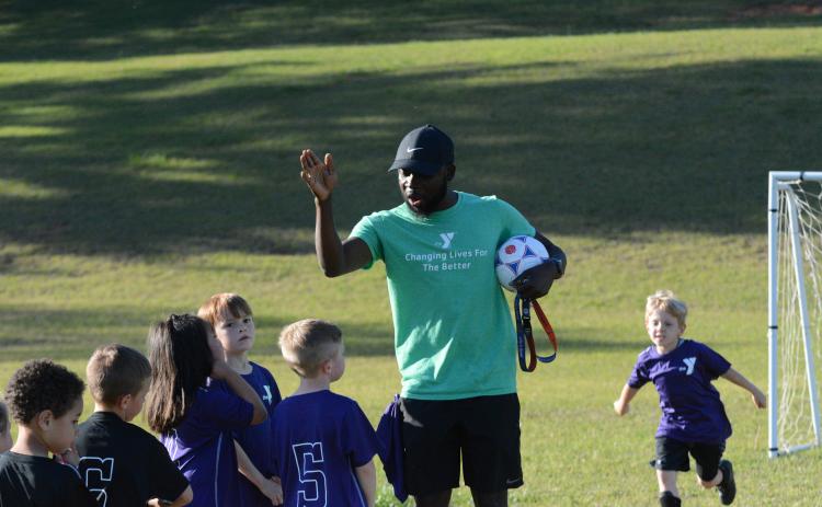 Bell Family YMCA’s sports director Kurve Augustine coaching up a 5U soccer team during a game on Tuesday.