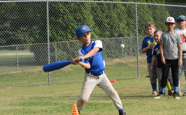 Knox Payne (left) works on seeing the ball all the way through during HCHS baseball’s camp on June 5-8.