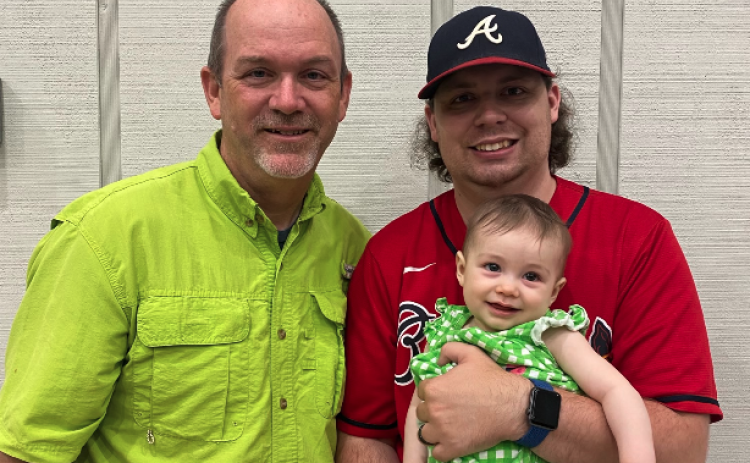 Todd London (left) stands next to his son Benjamin London (right), who is holding a very happy Baylor Kate. 