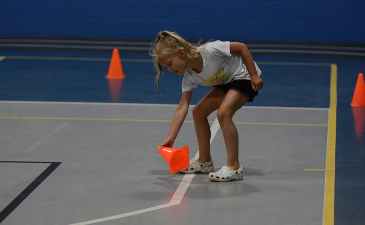 Layla Reagin plays in a game to help work out the core during the YMCA Kids Fit Camp.