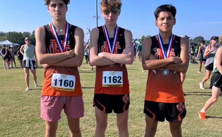 Pictured from left is Nate Harris, Braydon Lane, and Luis Genchi as they placed in the Top 20 to propel the boys team to a fifth place overall finish in the North Georgia Championships Aug.26 in Jefferson.