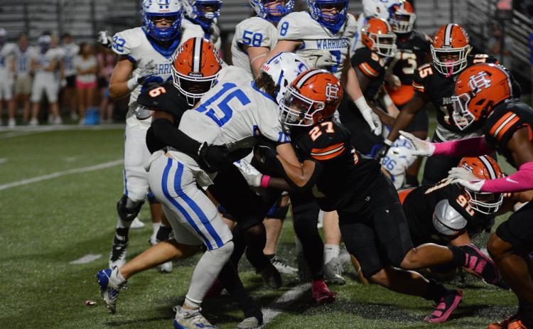 Jamir Rucker (6) and Tay Martin (27) tackle the Warriors quarterback in the 27-16 win.