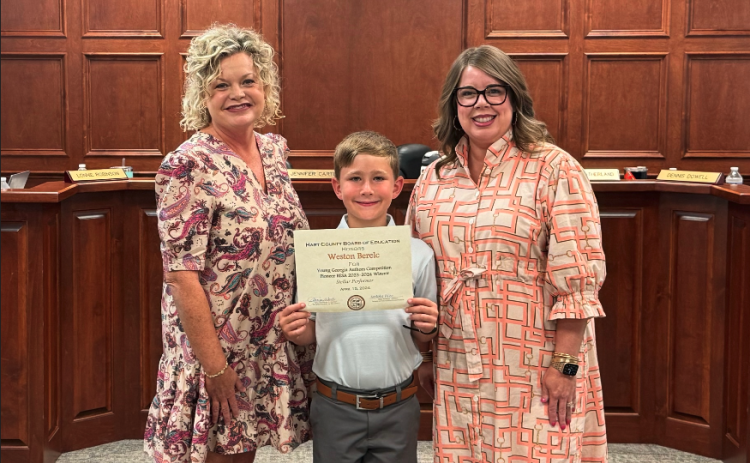 The Hart County Board of Education honored South Hart second grader Weston Berelc (center) as a Georgia Young Author Award winner. Berelc is pictured with Superintendent Jennifer Carter (left) and Board Chair Kim Pierce (right).